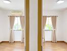 Bedroom with wooden flooring and windows with curtains