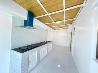 Modern kitchen with gas stove, extractor hood, and white cabinetry