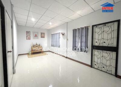 Spacious living room with tiled floor and decorative wall features.