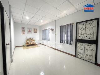 Spacious living room with tiled floor and decorative wall features.