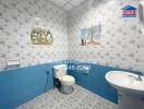 Bathroom with blue and white tile decor, featuring a toilet, sink, and wall art