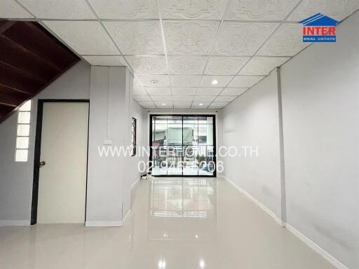 Minimalist living room with tiled ceiling and glossy floor