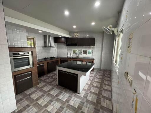 Modern kitchen with tiled floor, dark cabinets, and stainless steel appliances