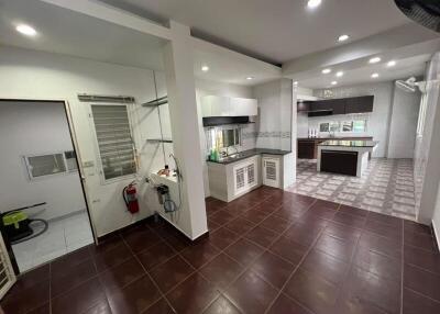 Spacious kitchen with modern fixtures and adjacent utility area