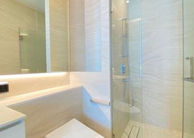 Modern bathroom with glass-enclosed shower and beige tiles