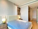 Spacious bedroom with a large bed, modern lighting, and ample storage