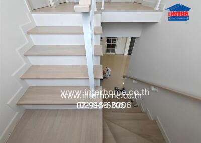 Modern staircase with wooden steps and white railings