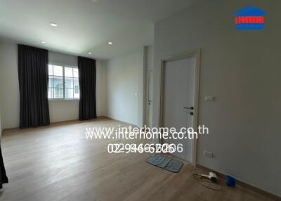 Spacious empty bedroom with wooden flooring and large window