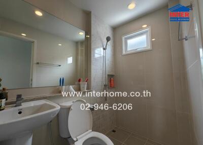 Modern bathroom with sink, toilet, shower, and mirror