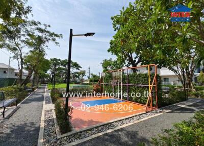 Outdoor recreational space with a basketball court and pathway