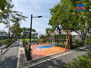 Outdoor recreational space with a basketball court and pathway
