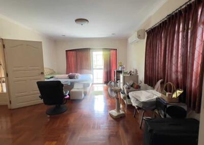 Bedroom with large window, desk, and multiple furniture pieces