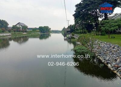 Serene view of a river with nearby houses and trees