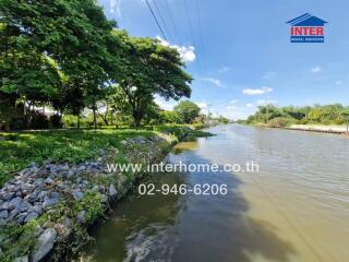 Beautiful outdoor space by the canal with greenery and clear sky