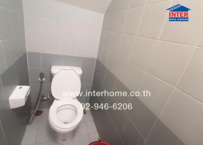 Bathroom with gray and white tiles and a white toilet