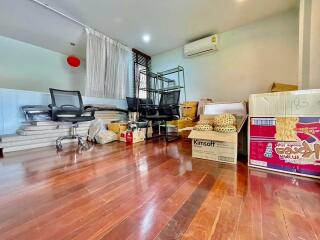 Room with wooden flooring and scattered boxes