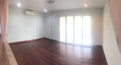 Spacious living room with hardwood floors and large windows