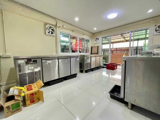 Modern kitchen with stainless steel appliances and gleaming white tile floor