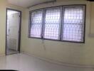 Empty room with barred windows and a door