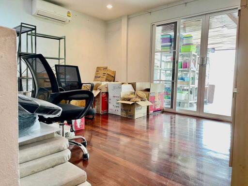 Room with office chairs, cardboard boxes, and sliding glass doors