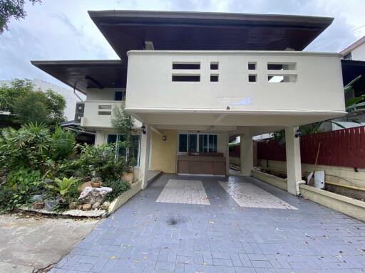 Front view of a house with a driveway and garden