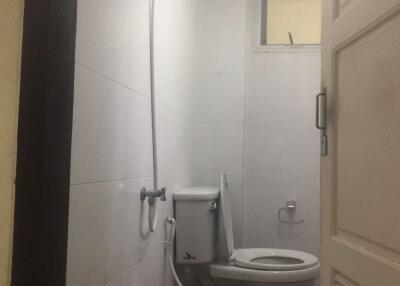 Small bathroom with showerhead, toilet, and window