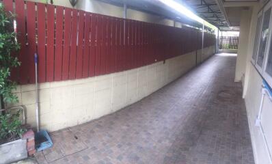 Covered walkway with red wooden fence