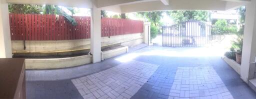 Carport with gate and surrounding greenery