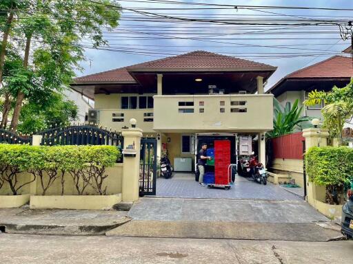 Exterior view of a two-story house with a gated driveway