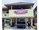 Front view of the house with a truck parked in the driveway and a 'For Sale' banner