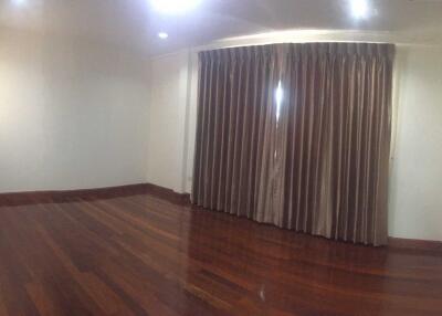 Empty bedroom with wooden floor and large curtains