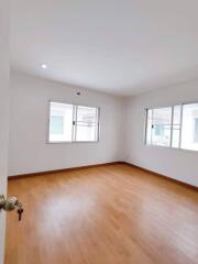 Bright bedroom with wooden floor and large windows