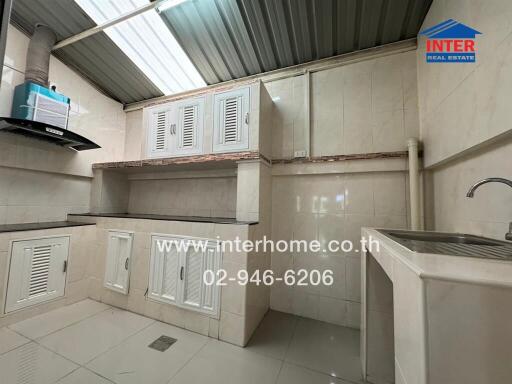 Modern kitchen with white cabinetry and stainless steel sink