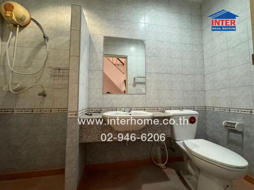 Bathroom with toilet, sink, shower, and mirror