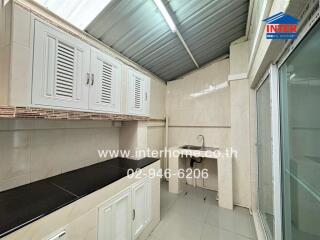 Clean kitchen with white cabinetry and ample counter space