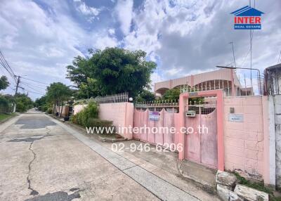 Street view of property exterior featuring pink walls and gate