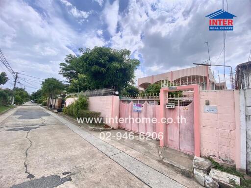 Street view of property exterior featuring pink walls and gate