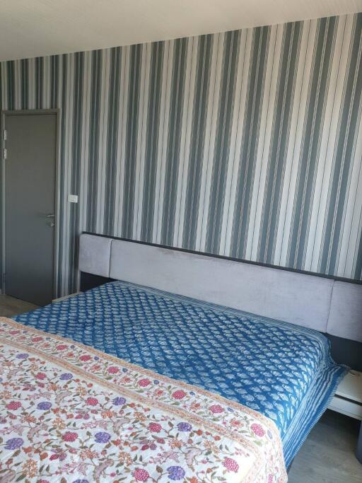 Bedroom with a striped wallpaper and a double bed