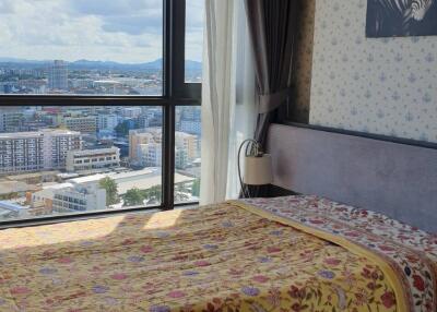 Bedroom with a large window offering a city view