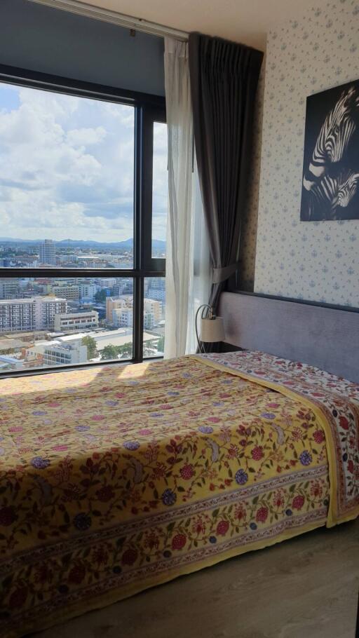 Bedroom with a large window offering a city view