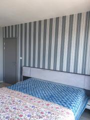 Bedroom with striped wallpaper and bed