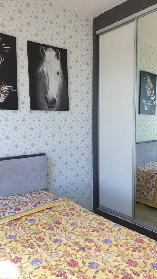 Cozy bedroom with floral bedding and mirrored closet