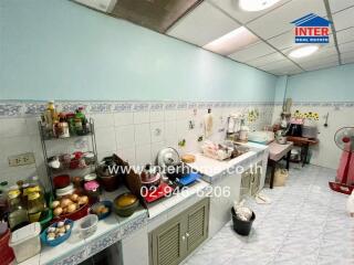 Spacious kitchen with various utensils and food items on counters and shelves