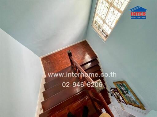 Top view of a staircase with wooden steps and a decorative window