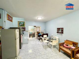 Living area with dining table and chairs, adjacent to kitchen