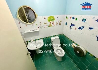 Bathroom with toilet, sink, mirror, and wall decorations