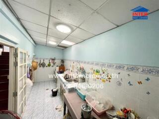 A well-lit kitchen with light blue walls, various cabinets, and cooking utensils.