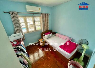 Bedroom with natural light, air conditioner, bed, window, and clothing storage