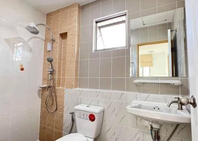 Modern bathroom with shower, toilet, sink and window