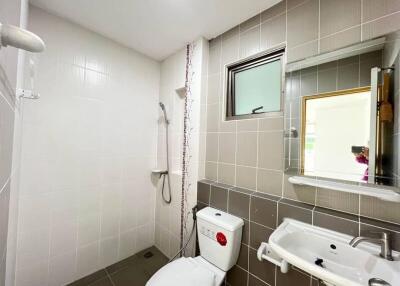 Modern bathroom with shower area, toilet, and sink